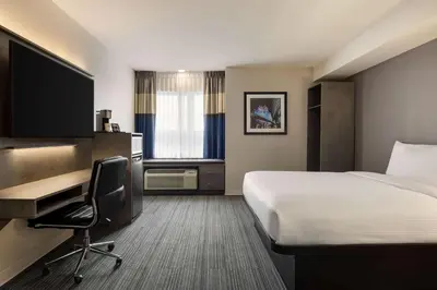 a hotel room with a bed and a desk at Microtel Inn & Suites by Wyndham Boisbriand in Sainte-Thérèse-de-Blainville