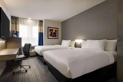 a hotel room with two beds and a desk at Microtel Inn & Suites by Wyndham Boisbriand in Sainte-Thérèse-de-Blainville