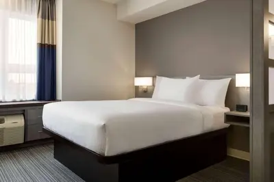 a hotel room with a large bed with white pillows at Microtel Inn & Suites by Wyndham Boisbriand in Sainte-Thérèse-de-Blainville