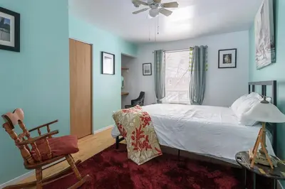 a bedroom with a bed and a chair and a window at Maison Sherman's house in Scotstown