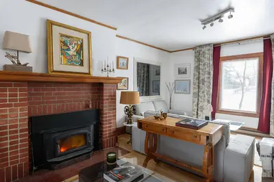 a living room with a brick fireplace and a couch at Maison Sherman's house in Scotstown