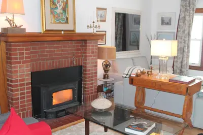 a living room with a brick fireplace and a table at Maison Sherman's house in Scotstown