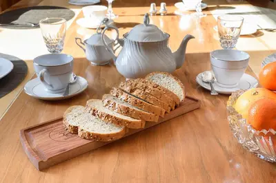a wooden table with bread and tea cups and oranges at Maison Sherman's house in Scotstown