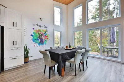 a dining room with a table and chairs at Chalet Le Cerf du Lac in Disraeli