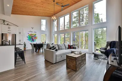 a living room with a couch and a table at Chalet Le Cerf du Lac in Disraeli
