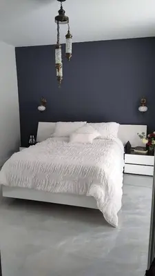 a bedroom with a white bed with a blue wall at Magnifique Chalet En Montagne in Shefford