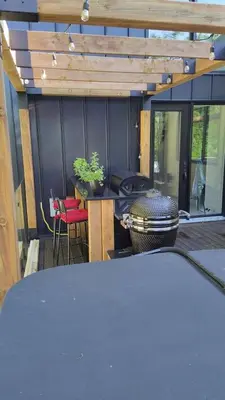 a screened in porch with a grill and a table at Magnifique Chalet En Montagne in Shefford