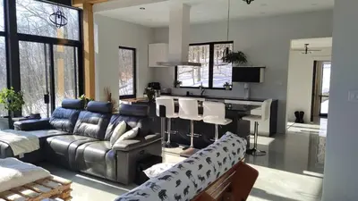a living room with a couch and a table at Magnifique Chalet En Montagne in Shefford