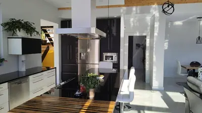 a kitchen with a stainless steel refrigerator and a table at Magnifique Chalet En Montagne in Shefford