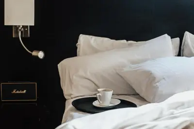 a cup of coffee on a tray on a bed at Le Petit Hotel Notre Dame in Montréal