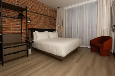 a bedroom with a bed and a brick wall at Le Petit Hotel Notre Dame in Montréal