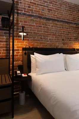 a bedroom with a bed and a brick wall at Le Petit Hotel Notre Dame in Montréal