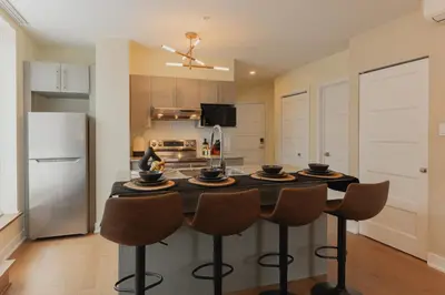 a kitchen with a table with chairs and a refrigerator at Rozenhaus Hotel Montreal in Montréal