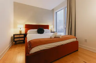 a bedroom with a large bed with a large window at Rozenhaus Hotel Montreal in Montréal