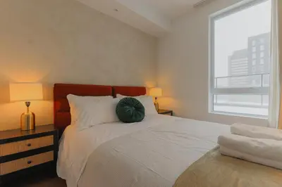 a bedroom with a bed with a green pillow on it at Rozenhaus Hotel Montreal in Montréal