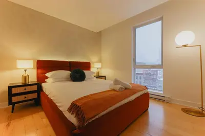 a bedroom with a bed and a large window at Rozenhaus Hotel Montreal in Montréal