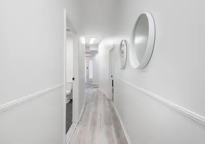 a hallway with white walls and a mirror on the wall at Luxurious 3BD Apt in heart of downtown 5 min walk to Bell Center in Montréal