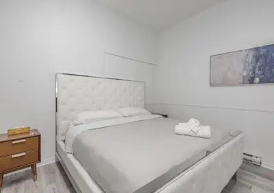 a white bed with a stuffed animal sitting on it at Luxurious 3BD Apt in heart of downtown 5 min walk to Bell Center in Montréal