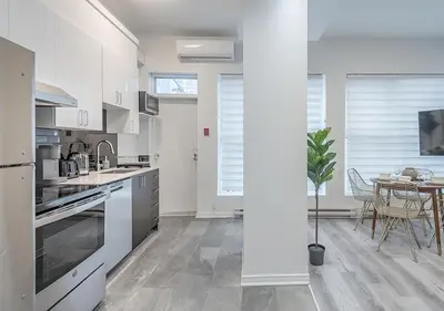 a kitchen with white appliances and a table with a potted plant at Luxurious 3BD Apt in heart of downtown 5 min walk to Bell Center in Montréal
