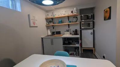 a small kitchen with a table and a microwave at Simplement l’Harmonie à Chambly in Chambly