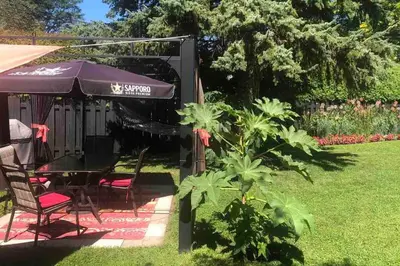 a table and chairs under an umbrella in a yard at Simplement l’Harmonie à Chambly in Chambly