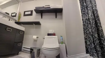 a bathroom with a toilet and a shelf on the wall at Simplement l’Harmonie à Chambly in Chambly