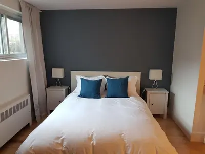 a bedroom with a large white bed with blue pillows at Bright and Spacious Studio Apartment in Montréal