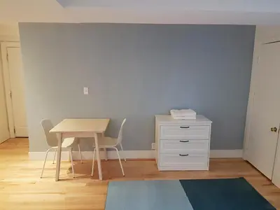 a room with a table and a table and a desk at Bright and Spacious Studio Apartment in Montréal