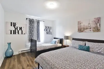 a bedroom with a bed and a couch at Comfortable 2-BEDROOM APARTMENT - Free and plentiful PARKING - 10 minutes to AIRPORT and 15 minutes to DOWNTOWN Montreal - Near Popular Waterfront Restaurants - located in Beautiful Lachine in Montréal