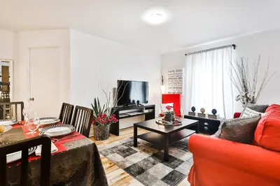 a living room with a couch and a table at Comfortable 2-BEDROOM APARTMENT - Free and plentiful PARKING - 10 minutes to AIRPORT and 15 minutes to DOWNTOWN Montreal - Near Popular Waterfront Restaurants - located in Beautiful Lachine in Montréal