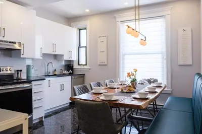 a kitchen and dining room with a table and chairs at The Parkview By MTLVacationRentals in Montréal
