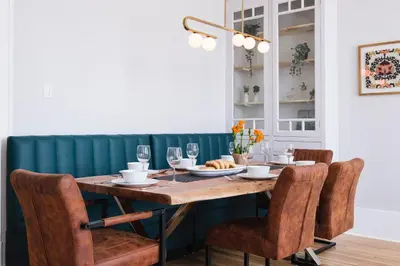 a dining room with a wooden table and chairs at The Parkview By MTLVacationRentals in Montréal
