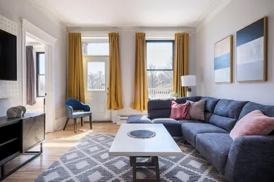 a living room with a blue couch and a table at The Parkview By MTLVacationRentals in Montréal