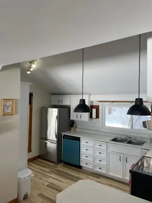 a kitchen with white cabinets and a stainless steel refrigerator at Oasis in Ascot Corner
