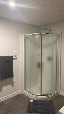 a glass shower in a bathroom with a black towel at Oasis in Ascot Corner