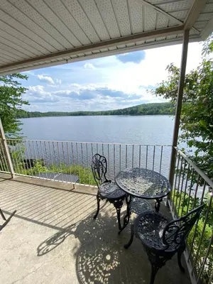 a porch with two chairs and a table with a view of a lake at Oasis in Ascot Corner
