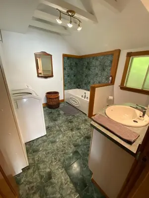 a bathroom with a tub and a sink and a bath tub at Oasis in Ascot Corner