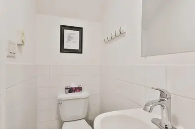 a white bathroom with a toilet and a sink at 250 METERS to METRO BERRI UQAM - Spacious fully equipped APARTMENTS - 1 FREE PARKING per unit - in-unit Washer & Dryer - fully stocked KITCHEN - WORKSPACE PROVIDED - FAST WIFI - 5 minute walk to the FAMOUS ST CATHERINE & ST DENIS STREET in Montréal
