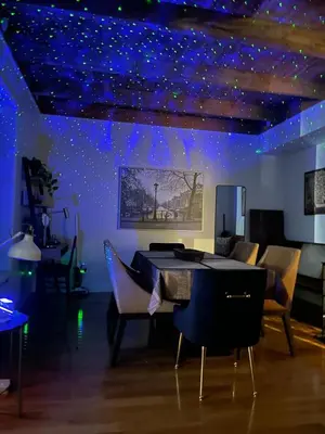 a room with a table and chairs with blue lights at STUNNING full APARTMENTS - stocked KITCHENS - WASHER & DRYERS - WORKSPACE PROVIDED - FAST WIFI - LOCATED on the FAMOUS ST Denis street - Near METRO MONT ROYAL in Montréal