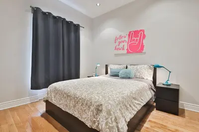 a bedroom with a bed and a black curtain at STUNNING full APARTMENTS - stocked KITCHENS - WASHER & DRYERS - WORKSPACE PROVIDED - FAST WIFI - LOCATED on the FAMOUS ST Denis street - Near METRO MONT ROYAL in Montréal