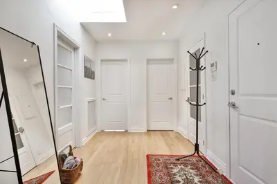 a hallway with white walls and a mirror at STUNNING full APARTMENTS - stocked KITCHENS - WASHER & DRYERS - WORKSPACE PROVIDED - FAST WIFI - LOCATED on the FAMOUS ST Denis street - Near METRO MONT ROYAL in Montréal