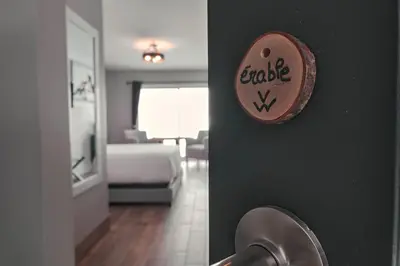 a wall with a plate on a wall with a living room at Étoile du Lac Lyster - Spa & Vue sur le Lac in Coaticook