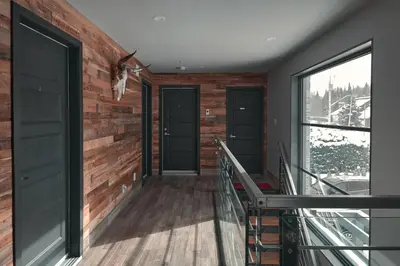 a room with two doors and a balcony at Étoile du Lac Lyster - Spa & Vue sur le Lac in Coaticook