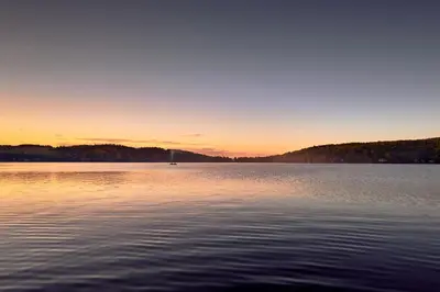 a large body of water with a sunset in the background at Étoile du Lac Lyster - Spa & Vue sur le Lac in Coaticook