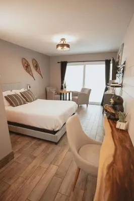 a bedroom with a bed and a living room at Étoile du Lac Lyster - Spa & Vue sur le Lac in Coaticook