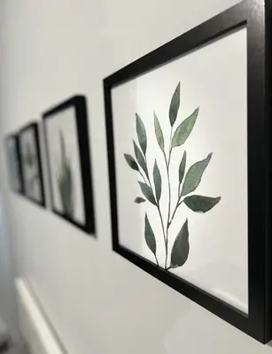 a row of framed pictures on a wall at Fantastique 3 chambres modernes au cœur de la ville in Montréal