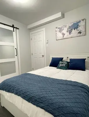 a bedroom with a large bed with a blue blanket at Fantastique 3 chambres modernes au cœur de la ville in Montréal