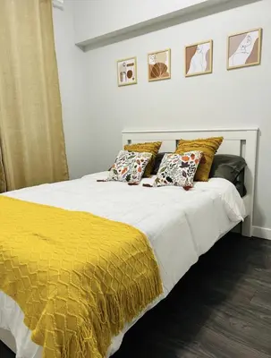 a bed with a yellow blanket and pillows on it at Fantastique 3 chambres modernes au cœur de la ville in Montréal