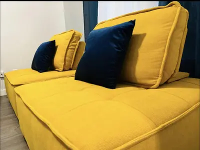 a yellow couch with two blue pillows on it at Fantastique 3 chambres modernes au cœur de la ville in Montréal