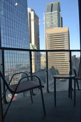 a table and chair on a balcony with a view of a city at Beautiful one bedroom downtown Condo with pool and free parking in Montréal